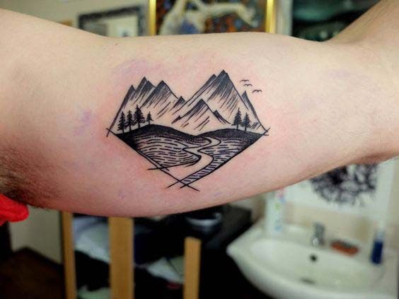 mountains inner bicep tattoo for men