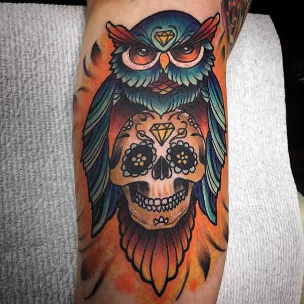 mens-colorful-sugar-skull-with-owl-tattoo-on-bicep-of-arm