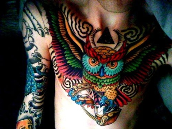 colorful spread-wing owl men's chest tattoo