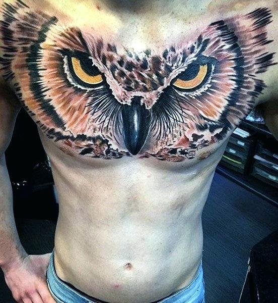 large owl face men's chest tattoo