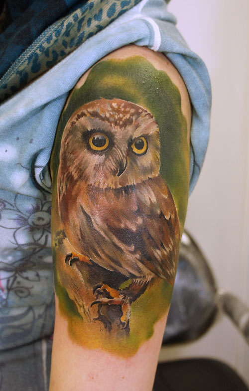 owl against green backdrop men's tattoo
