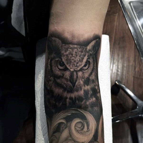 owl and feathers men's inner arm tattoo