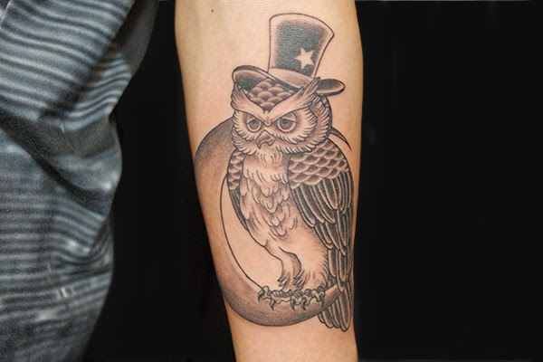 owl with top hat sitting on moon men's arm tattoo