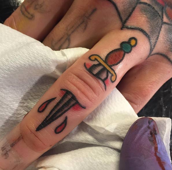 piercing dagger finger tattoo for men