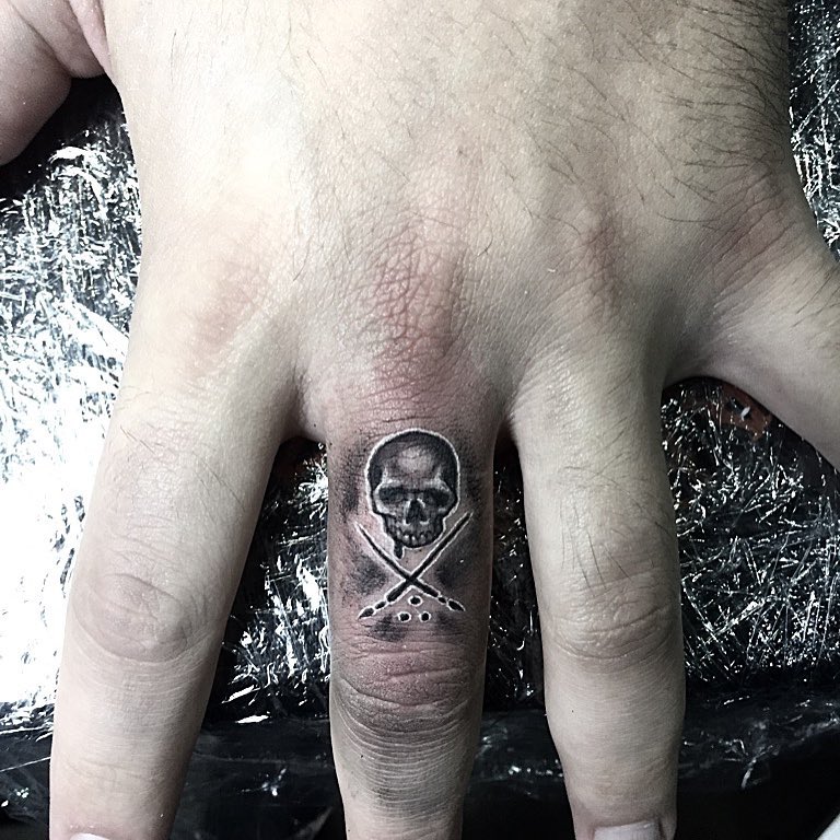 skull and swords finger tattoo for men