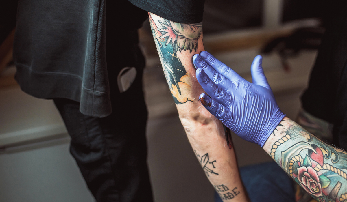 tattoo artist applying tattoo lotion