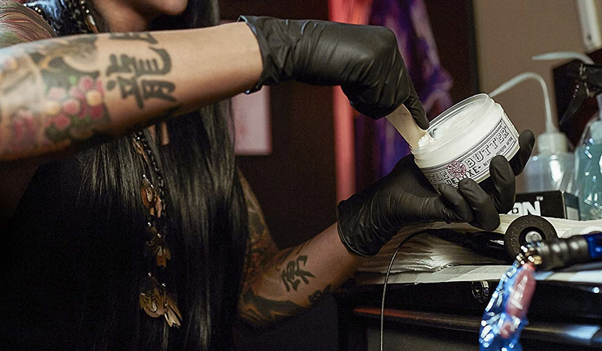 tattoo artist using healing lotion for tattoo