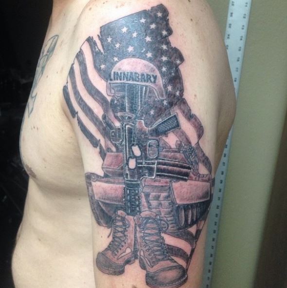 Tattoo Depicting the Imagery of a Marine, American Flag, and Weapon