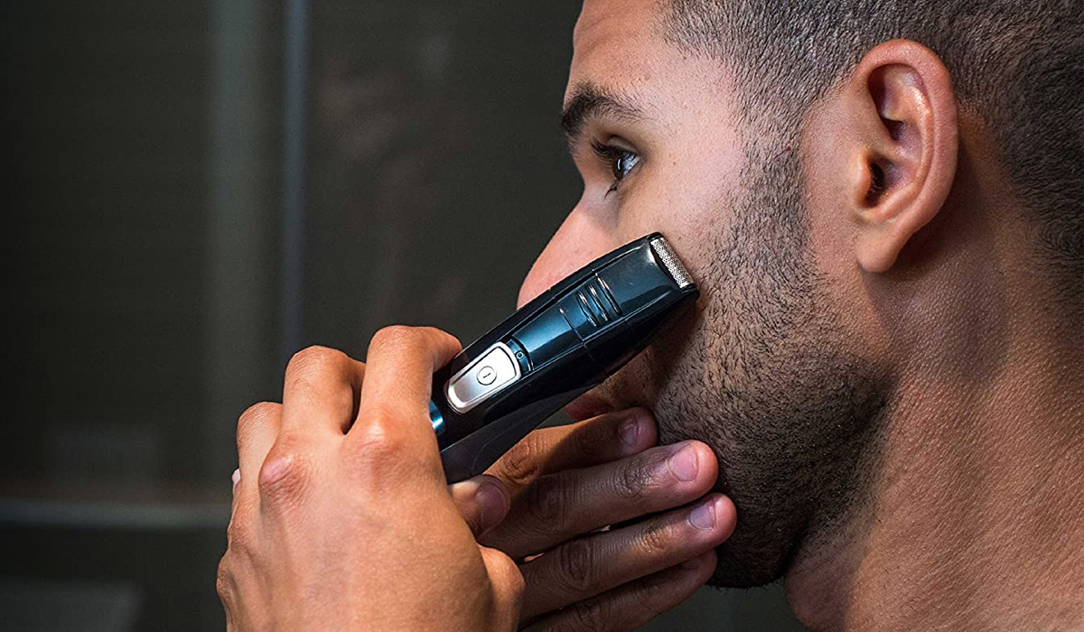 man trimming beard using a beard trimmer