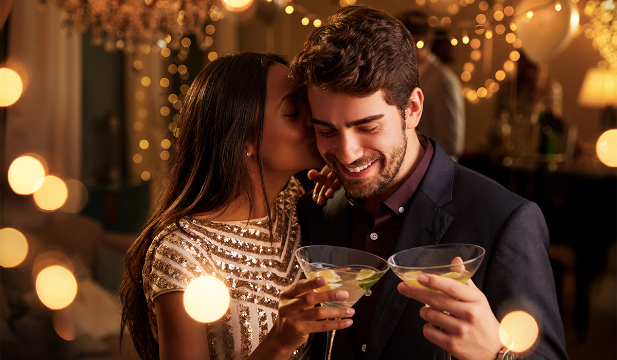 romantic couple enjoying cocktail at nye party